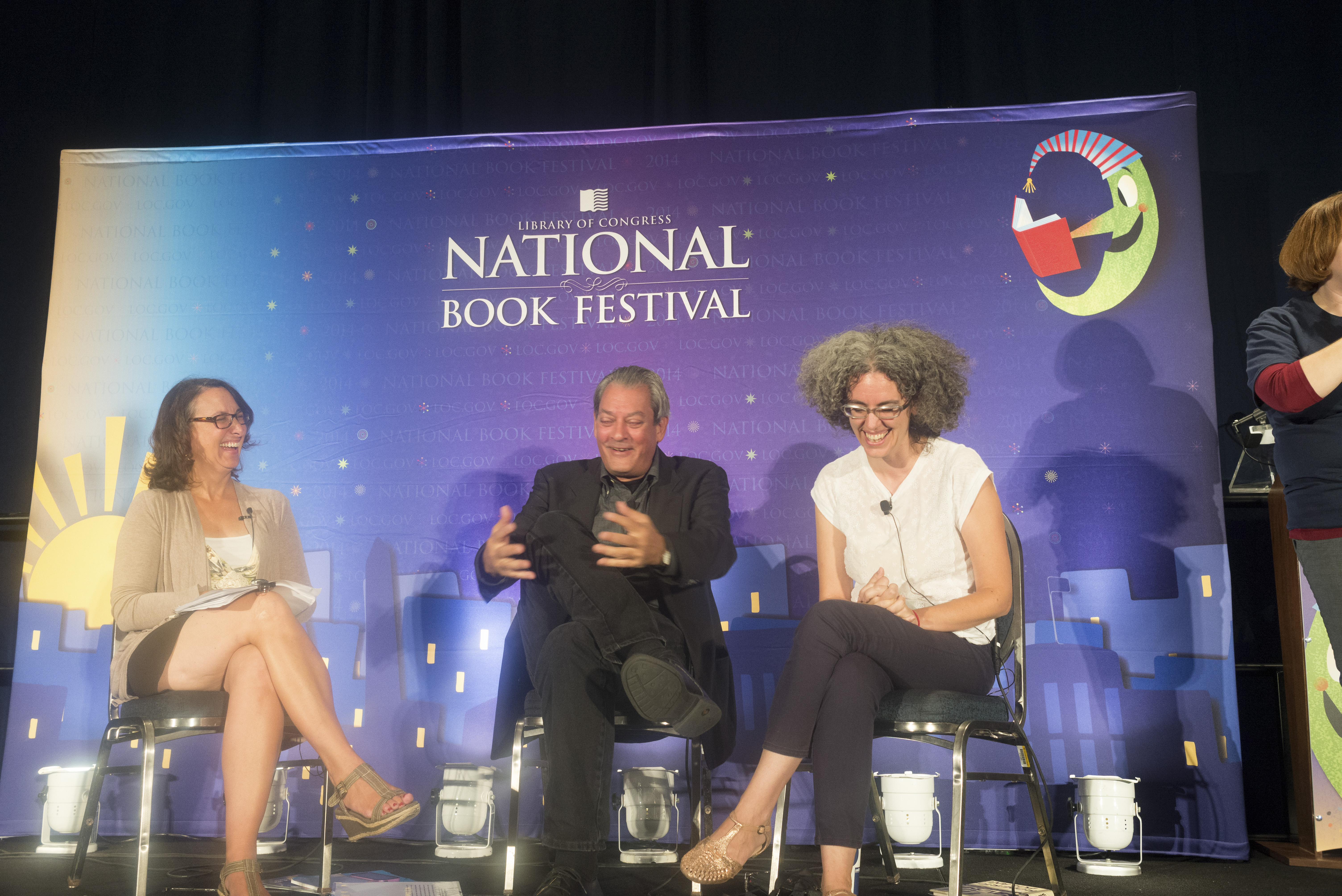 NEA Literature Director on stage smiling and laughing with NEA Creative Writing Fellow Paul Auster and NEA Literature Translation Fellow Natasha Wimmer.