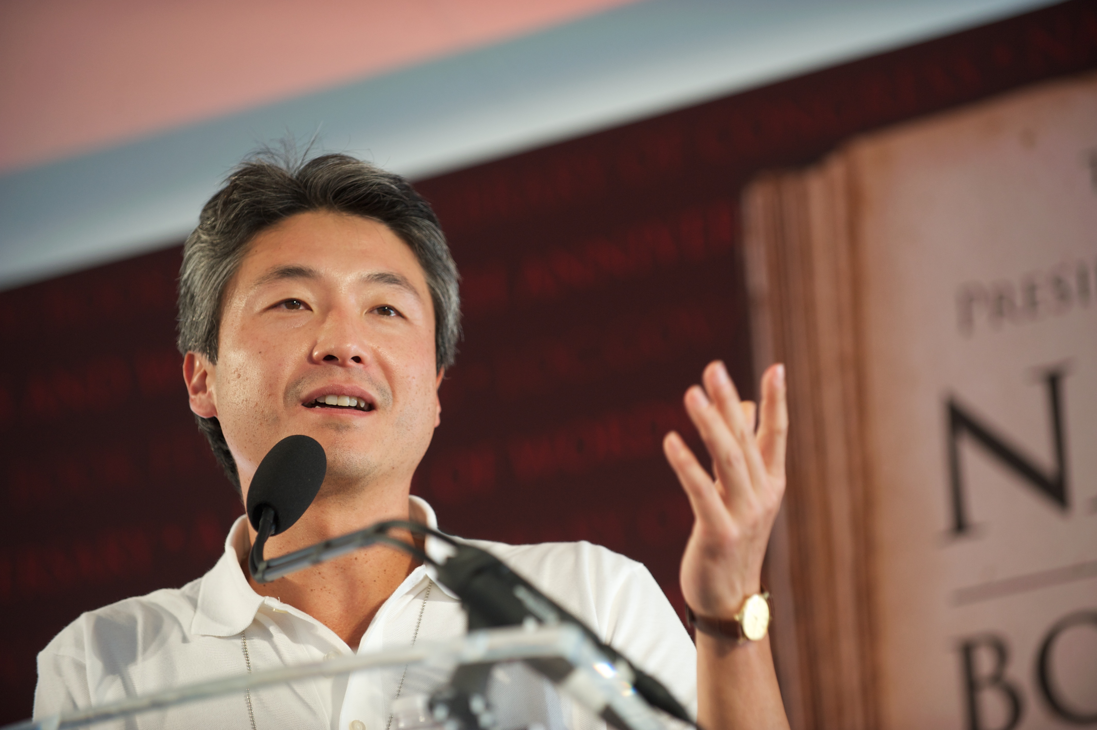 Headshot of novelist Chang-rae Lee speaking into a microphone.