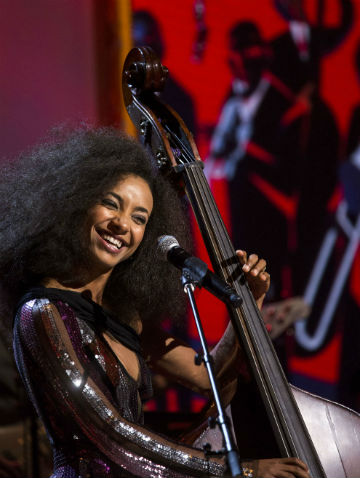 female bass player smiling and performing