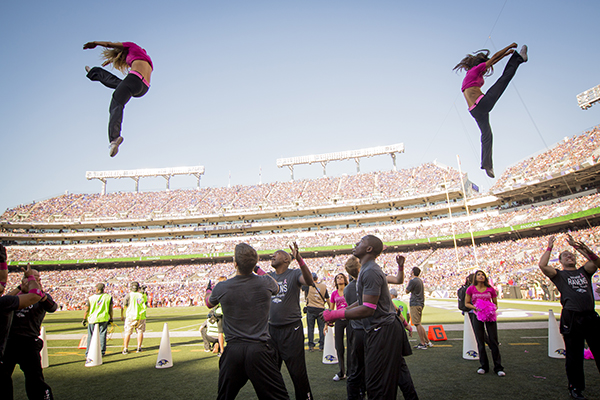 Female cheerleaders being thrown in the air by male cheerleaders.
