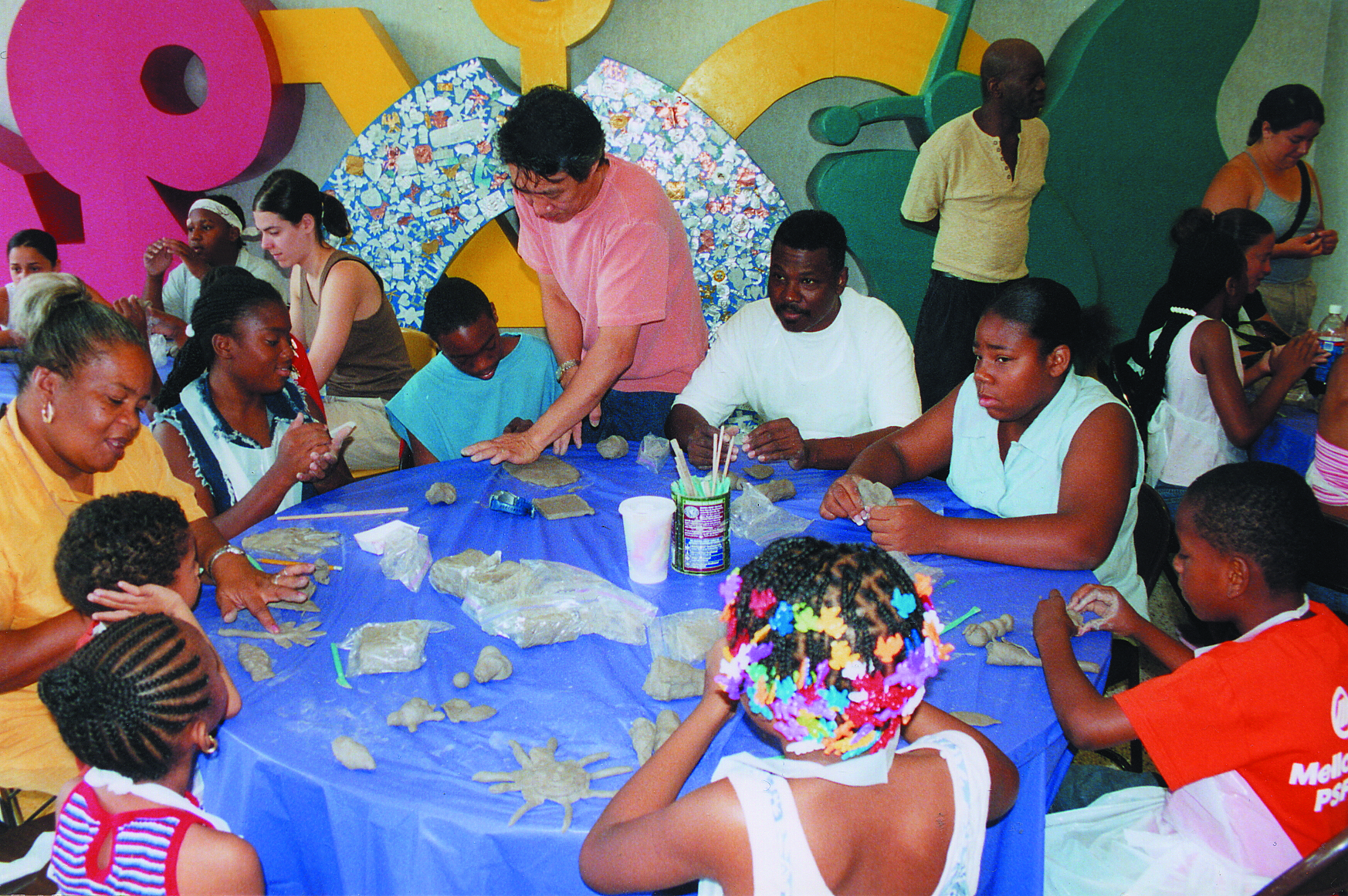 Adults and children working with clay. 