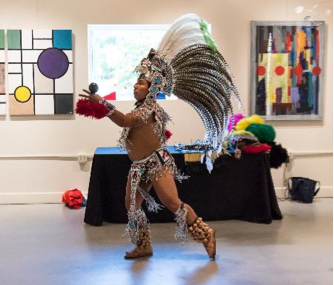 Man in Aztec garb performs a traditional dance in Arts Herndon