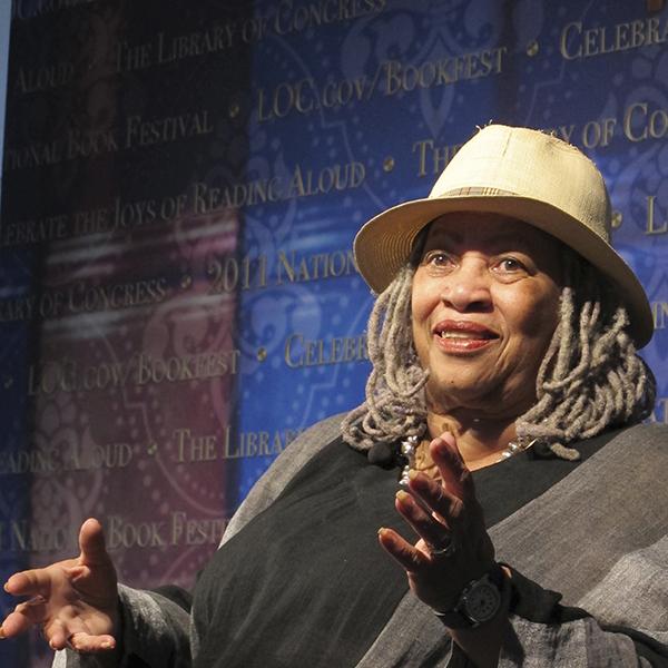 Toni Morrison wearing hat, sitting and gesturing with her hands