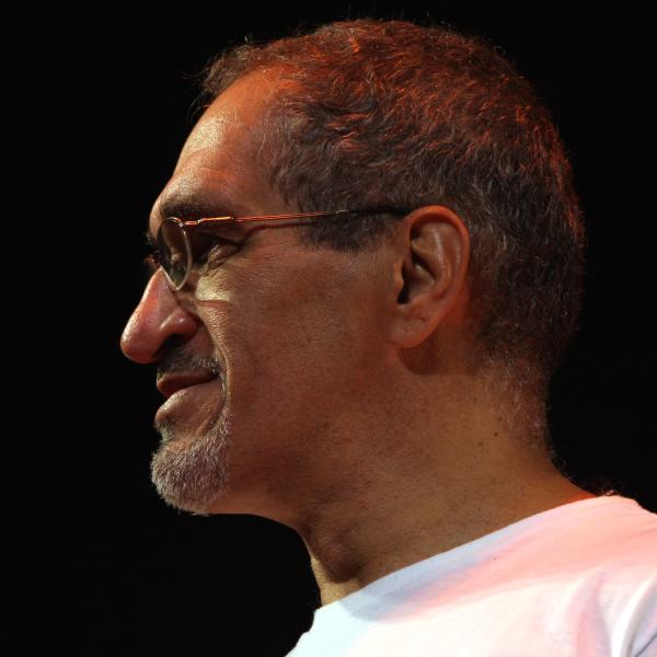 Latino man with short gray hair wearing glasses in profile. 