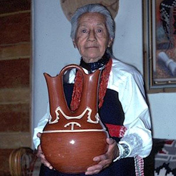 A woman holding a clay pot.