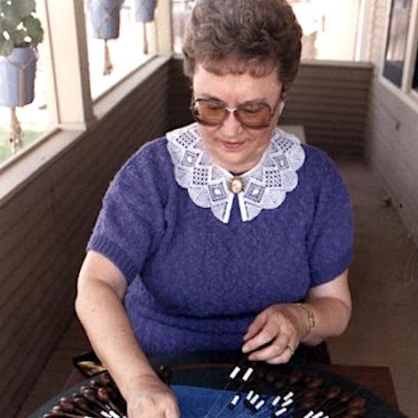 A woman workoing on a  of craft piece.