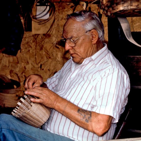 A man weaving a wicker basket.