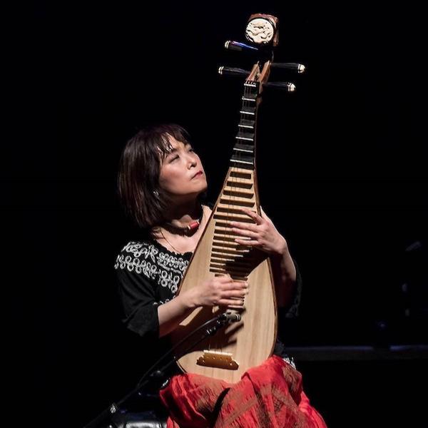 A woman playing a large string instyrument.