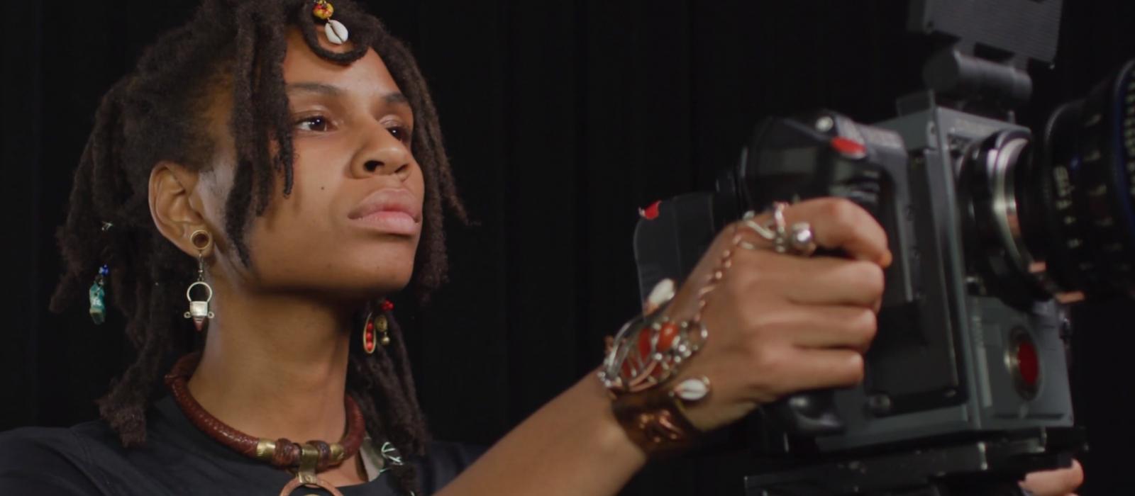 African-American women holding video camera.