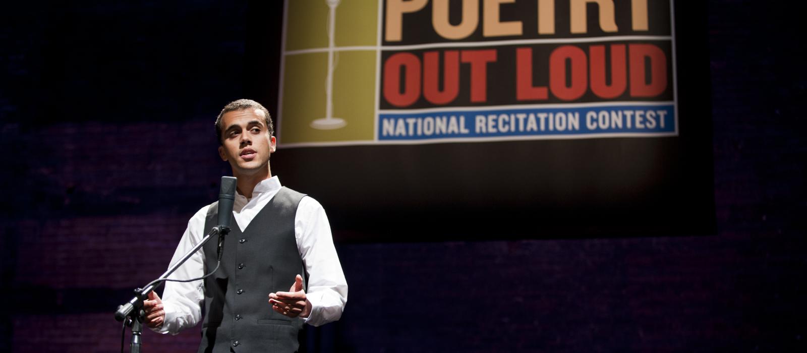 Teenage boy on stage reciting poetry.