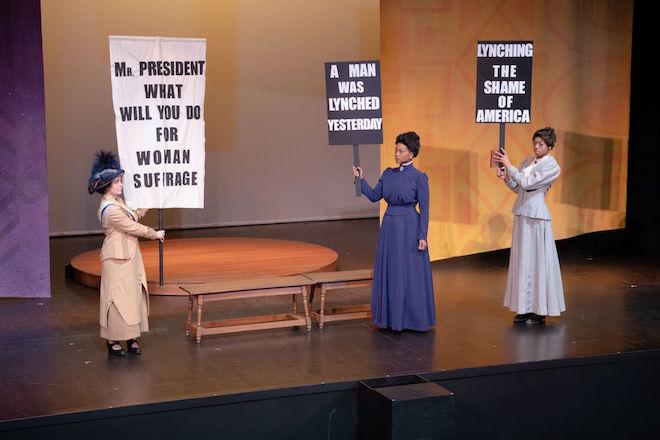 Three actresses portray suffragettes in a scene from a play