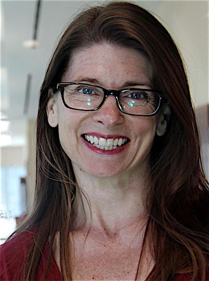 a white woman with long brown hair and glasses