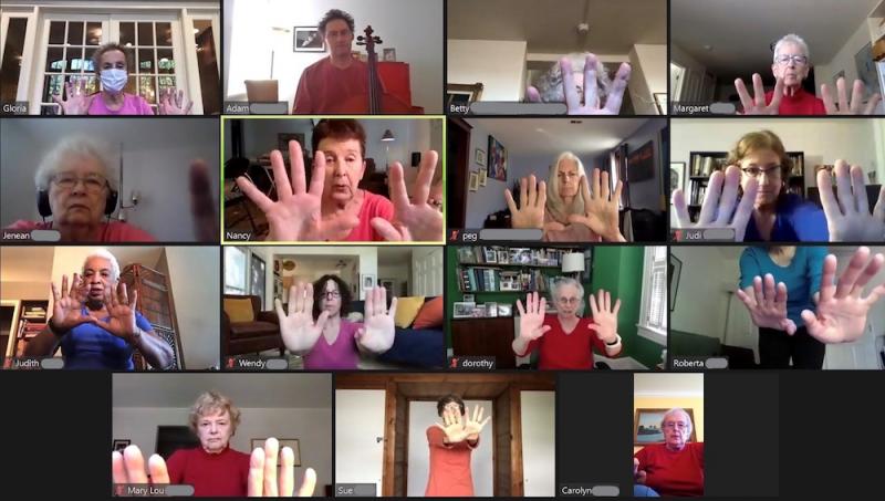 a screenshot of a Zoom dance class with older adults who are shown practicing hand gestures