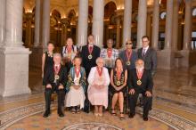 a group photo of the 2016 NEA National Heritage Fellows with Jane Chu and Cliff Murphy on the colonnaded mezzanine at the Library of Congress Jefferson building