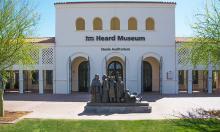 The entrance of Heard Museum, which has statues of American Indians posted in the front of the building. 