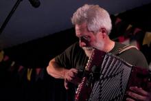 a man with gray hair playing an accordion