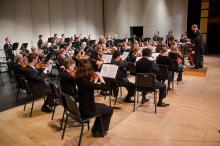 An orchestra sits on stage and performs