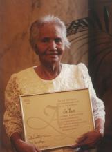 Elderly woman holding a certificate.