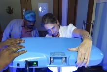 Woman and man looking at phototherapy machinery.