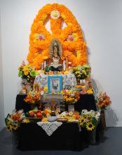 An altar made with flowers against a wall.