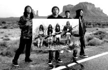 a group of young Native men holding an enlarged photo of a group of older Native people