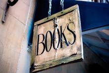 weathered hanging sign that says books in capital letters