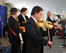 a shot from the side of a band comprising all men playing several instruments including a guitar and violin