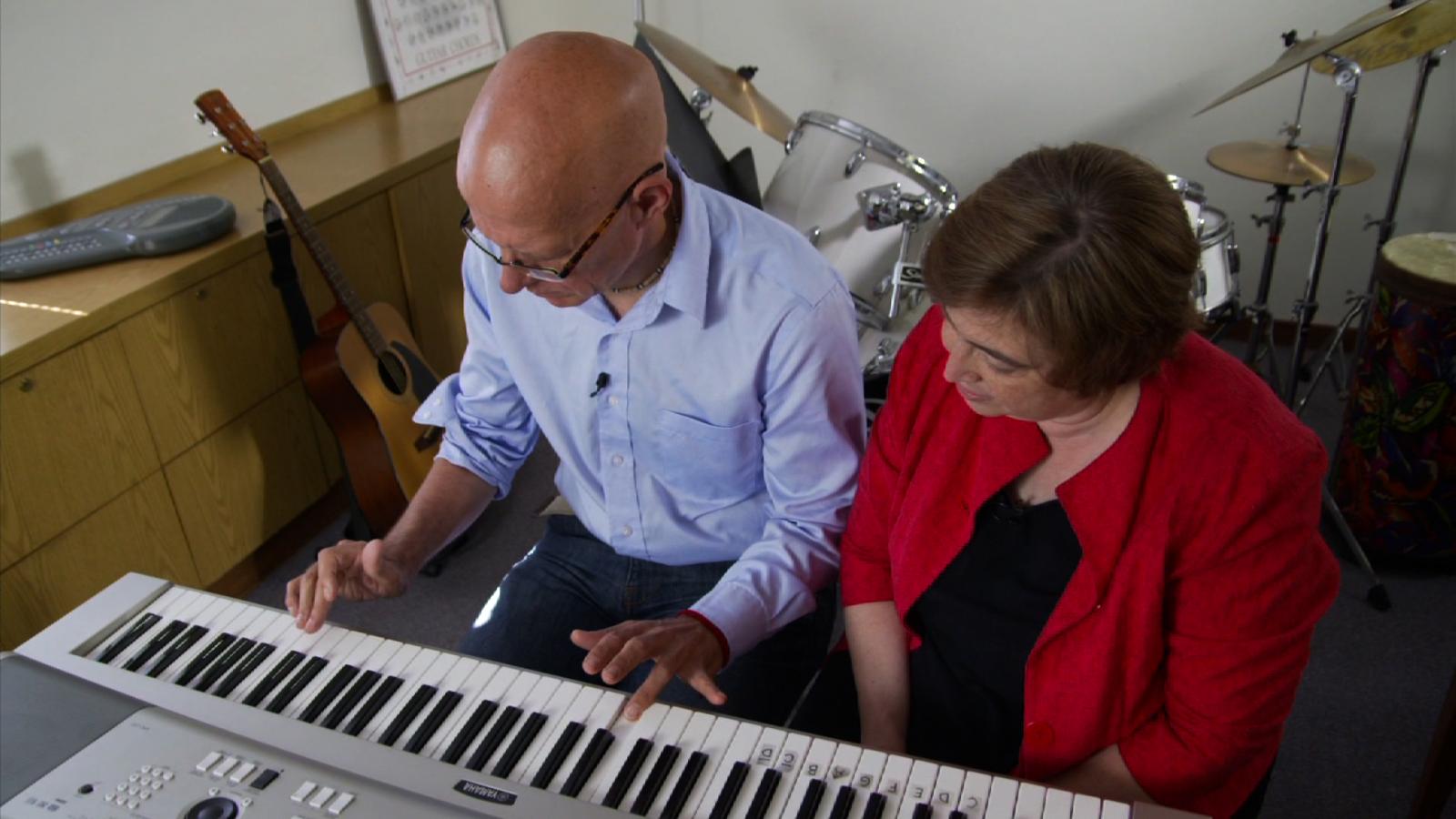 man plays keyboard with music therapist