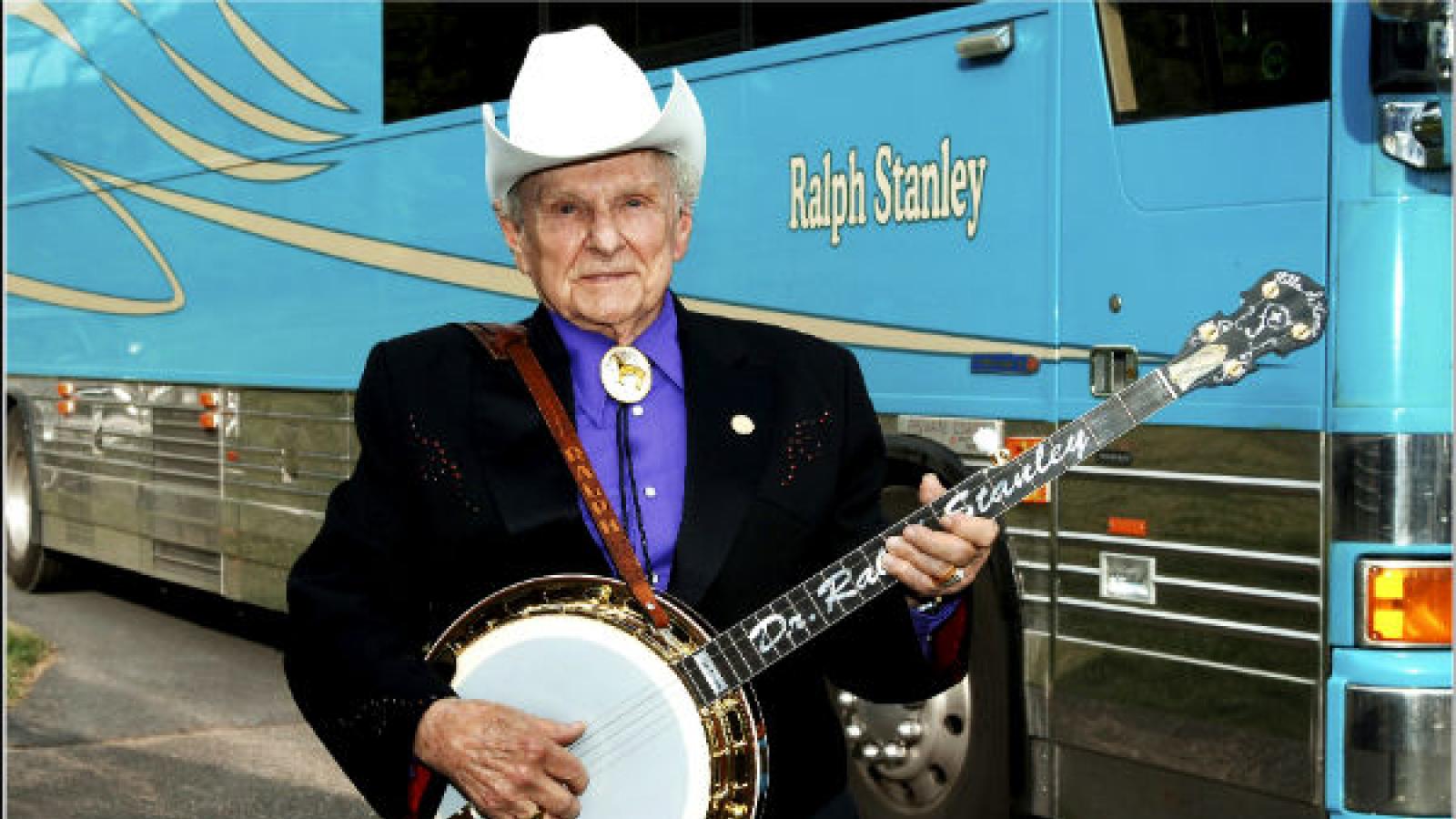 Ralph Stanley, bluegrass musician standing in front of his band's tour bus