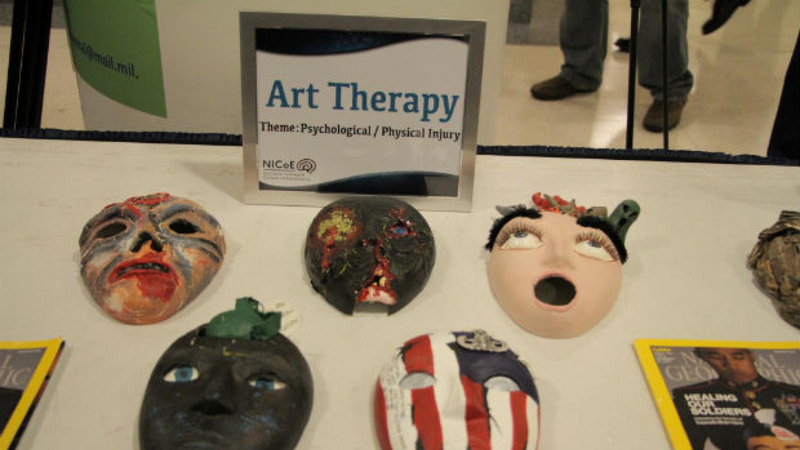 theater masks created by service members on display table