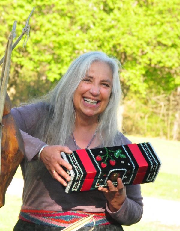 Woman laughing holding beaded box. 