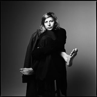 Black and white portrait of Aszure Barton with feet appearing from her cape where her arms should be