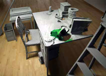 Sculture of an office desk and chair with phone and other sculptured objects on it