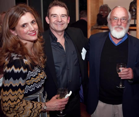  One woman and two men holding wine glasses and smiling for the camera