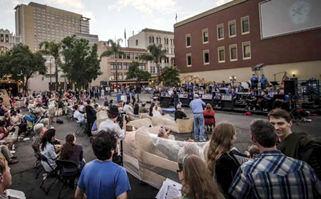 Crowd at an outdoor plaza looking at the living room installation