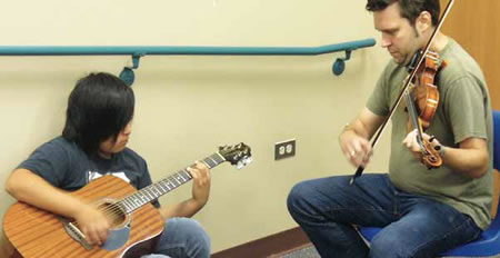 A member of ETHEL, the string quartet-in-residence, works with a student at the Navajo Nation city of Tuba City, Arizona. Photo by Clare Hoffman