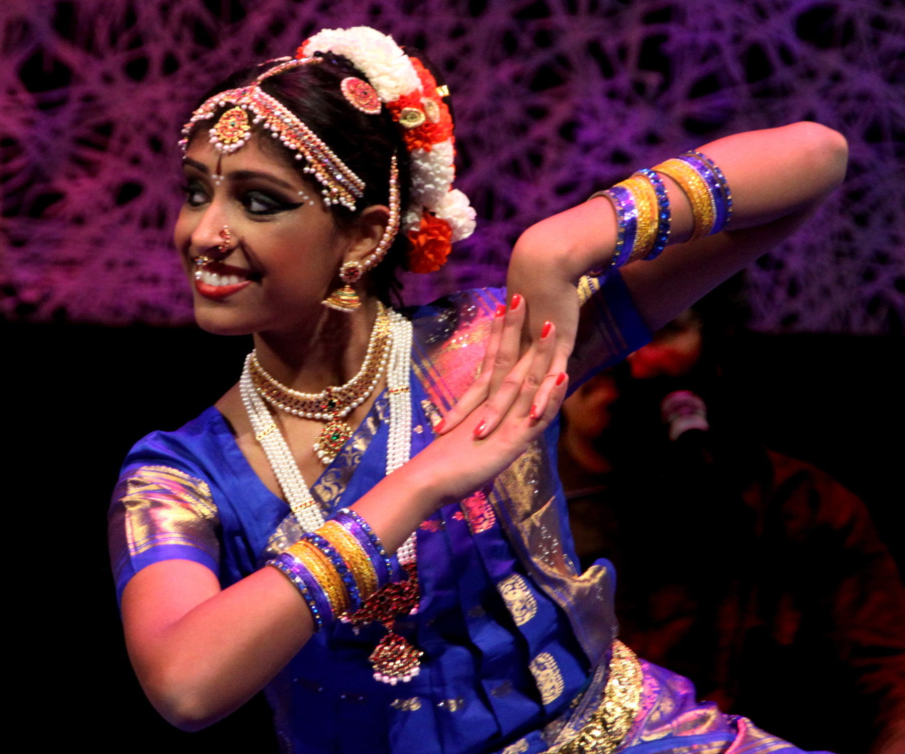 Indian woman dressed in traditional garb dances a classical bharatanatyam dance