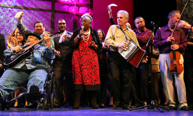Singers and musicians perform on a stage