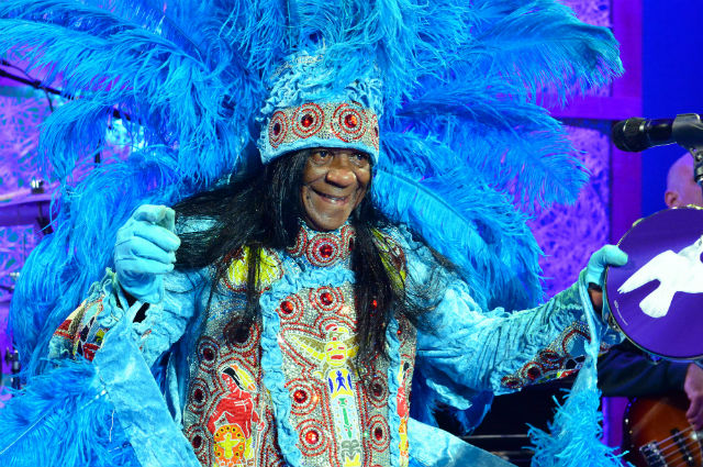 Man in blue feathered headdress and blue Indian costume