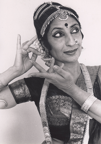 A woman wearing classical Indian dress strikes a heroine pose