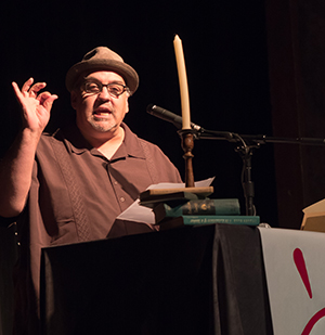 Man in a hat speaking at a lectern