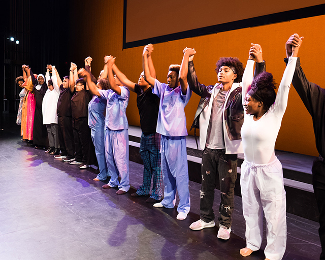 Teens lift their hands together before taking a group bow