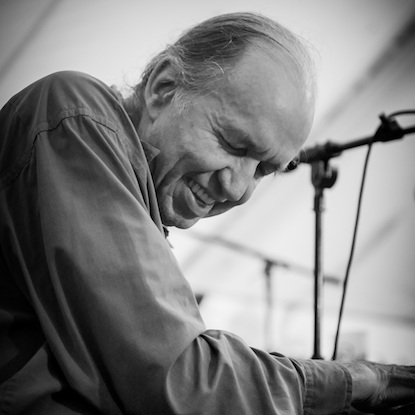 a man sits at a piano playing with his eyes closed