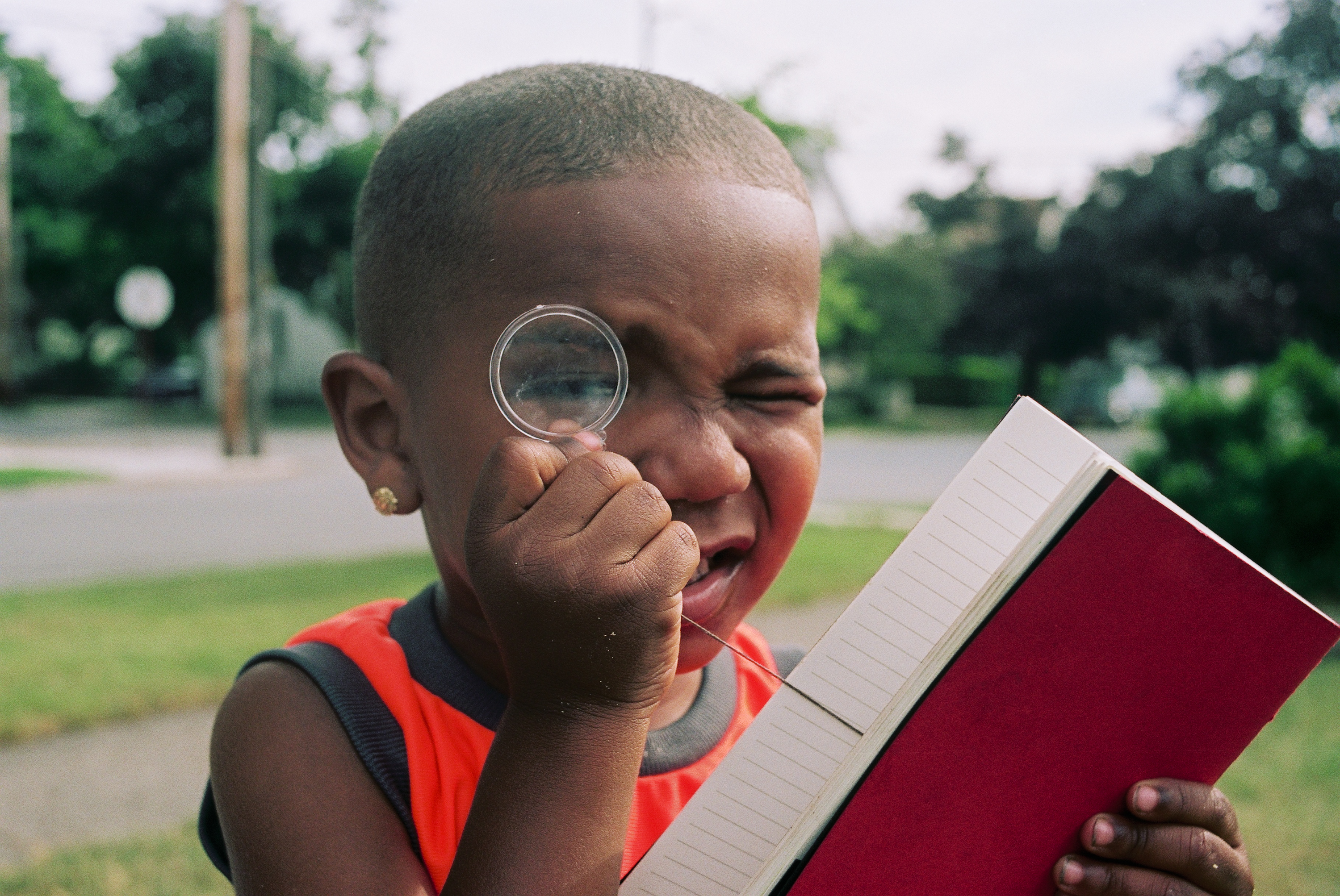 A child looks through a magnifying glass attached to a journal