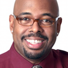 Headshot of a man with stand up base curl.