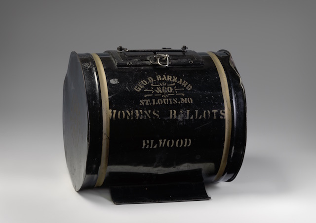 a round black japanned tin stencilled with Women's Ballot 