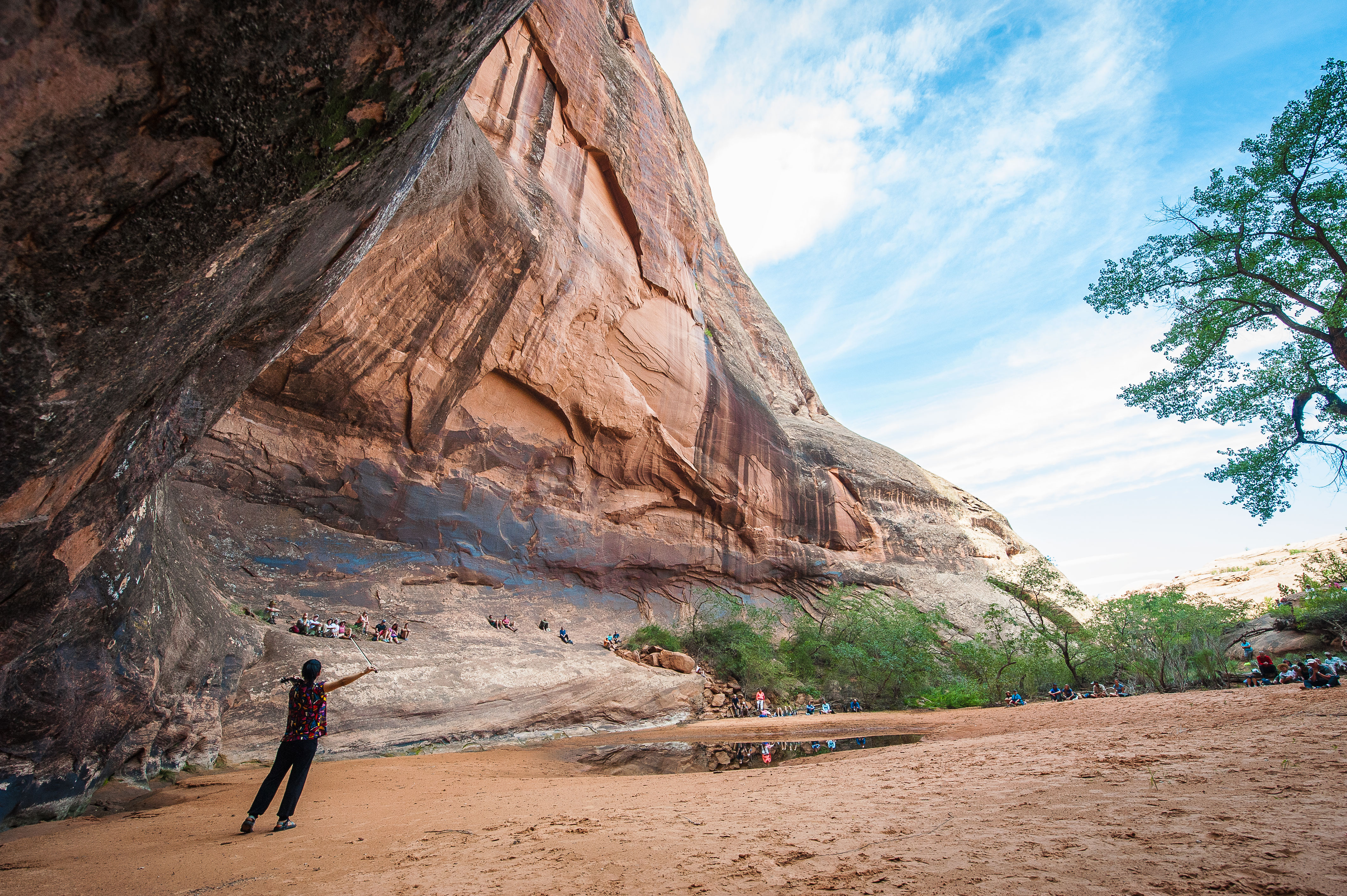 A woman standing on the edge of a red rock canyon overlooking the festival.