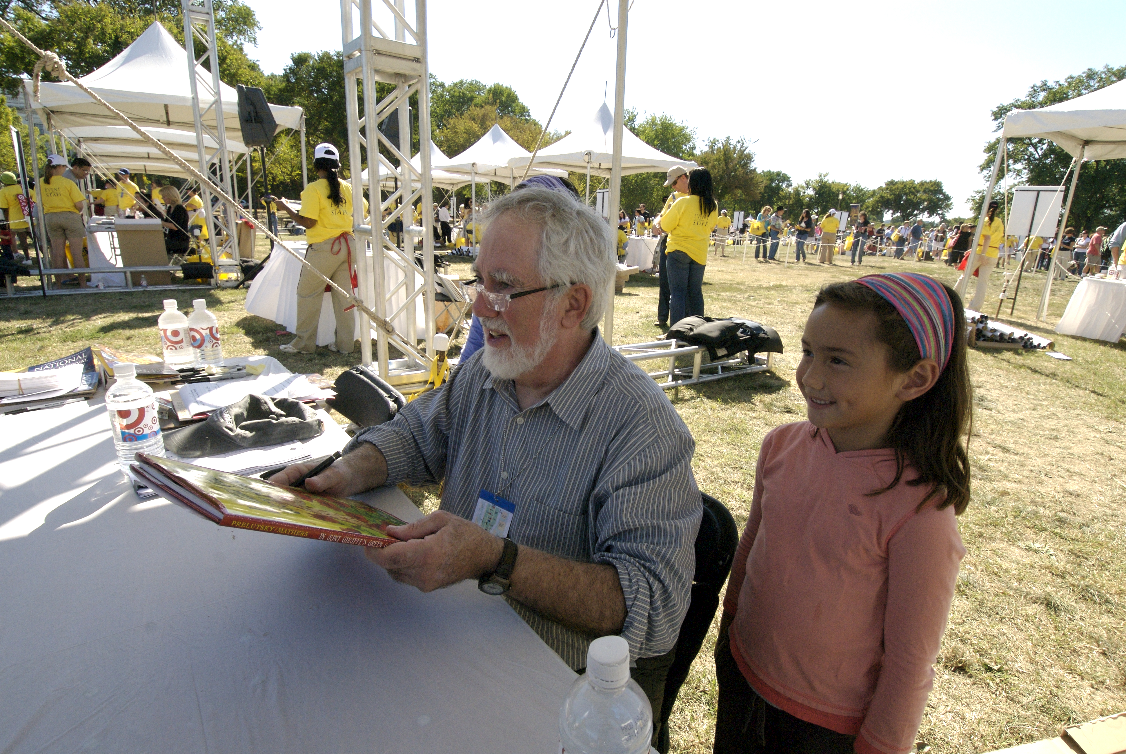 Jack Prelutsky standing next to a little girl while holding a book, smiling, and posing for a picture.