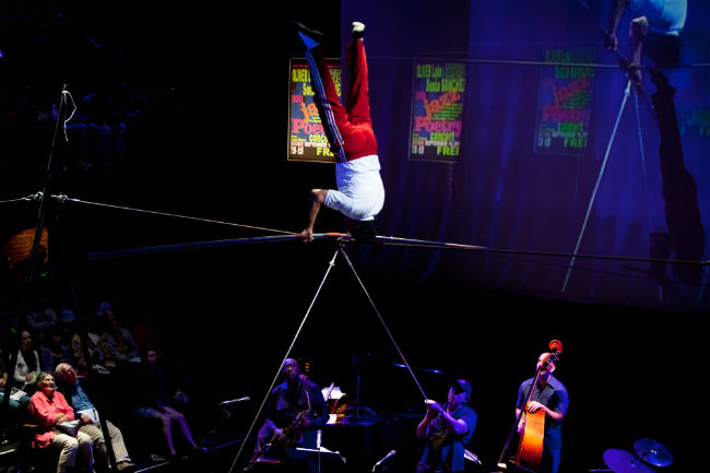 Tightrope walkers perform while a jazz band plays below