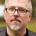 headshot of a man with book cover.